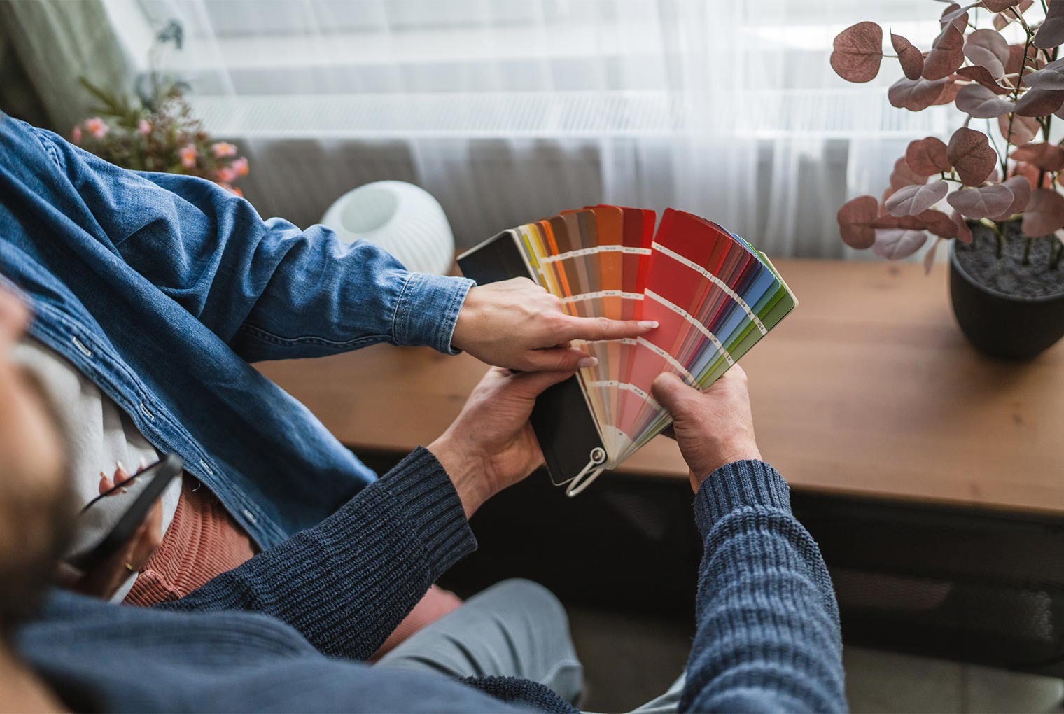 Couple picks paint colours from a fan deck for home decor inspiration.